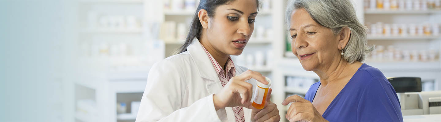 pharmacist helping customer with prescription